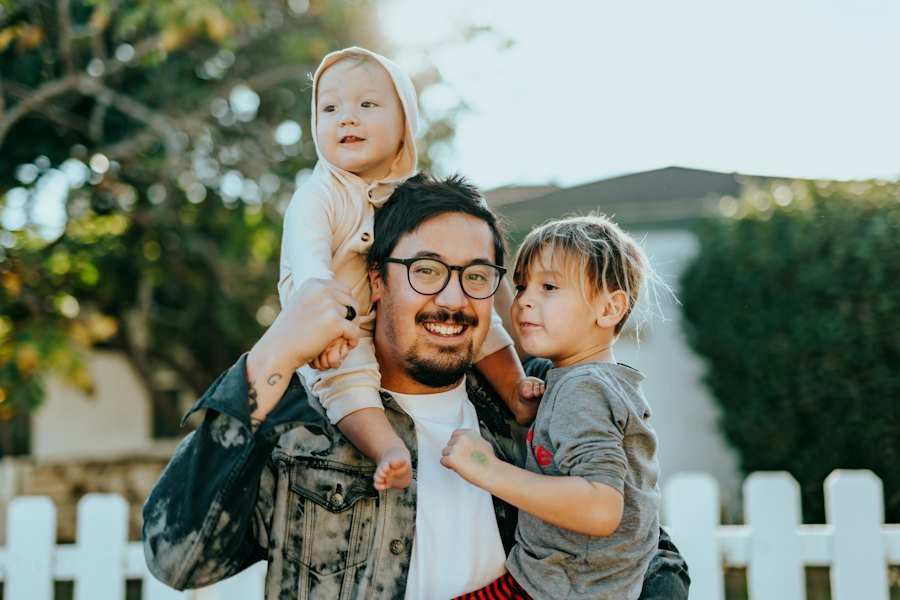 Smiling father with two young children outdoors