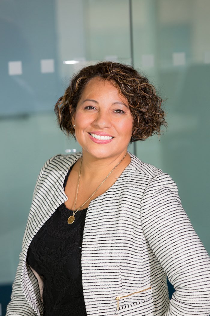 Smiling woman in a gray tweed jacket