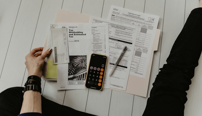 Person reviewing financial paperwork with a calculator